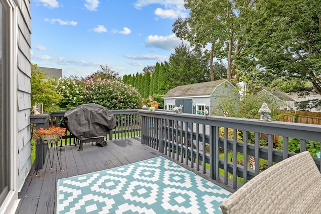 wooden terrace featuring an outbuilding and a grill