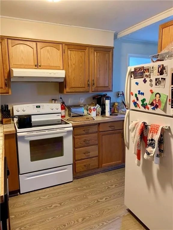 kitchen with white appliances and light hardwood / wood-style flooring