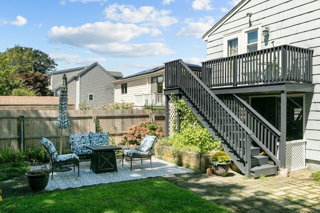 view of yard with a wooden deck, a patio area, stairway, fence, and a fire pit