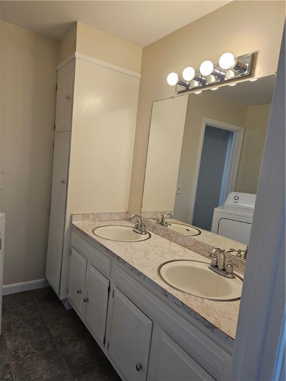 bathroom featuring washer / clothes dryer, double vanity, and a sink