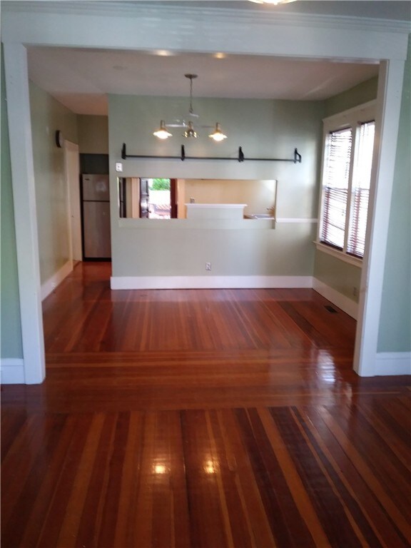 interior space with dark wood-type flooring and a notable chandelier