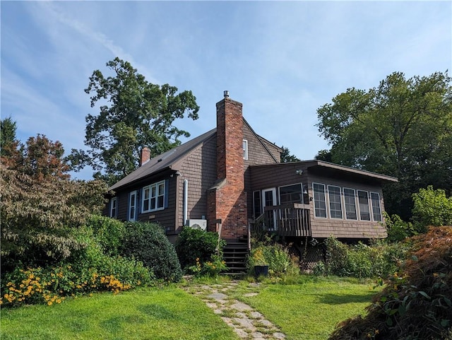 view of home's exterior featuring a lawn and a sunroom