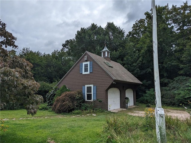 view of front of property with a garage, an outdoor structure, and a front yard