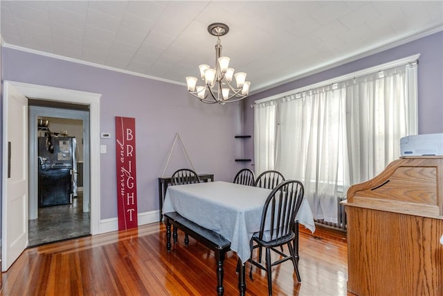 dining room featuring hardwood / wood-style floors, crown molding, and a chandelier