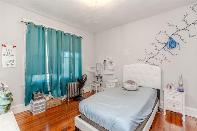 bedroom with wood-type flooring and radiator