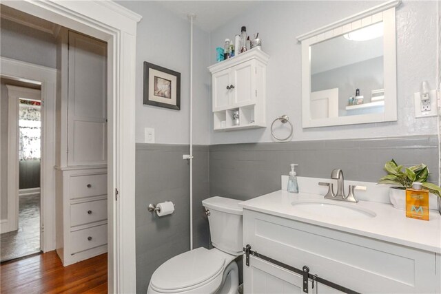 bathroom with toilet, hardwood / wood-style floors, and vanity