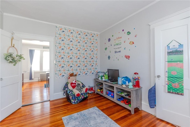 game room with crown molding, hardwood / wood-style floors, and radiator heating unit