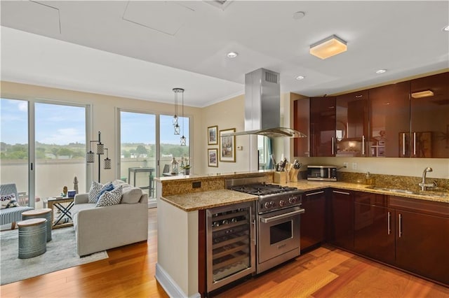 kitchen with kitchen peninsula, island exhaust hood, beverage cooler, stainless steel stove, and sink