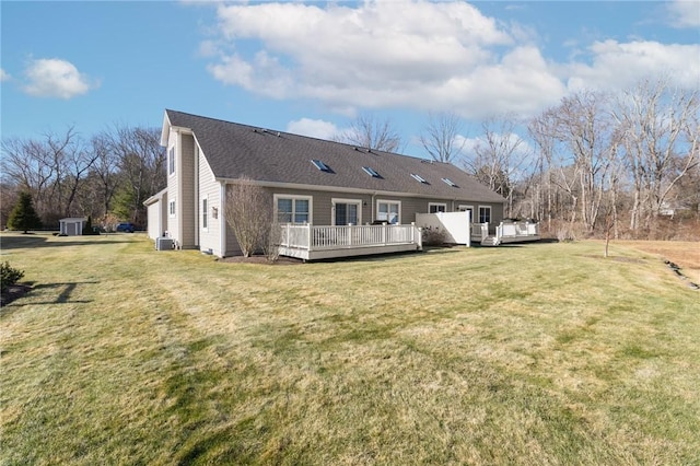 rear view of house featuring a deck and a lawn