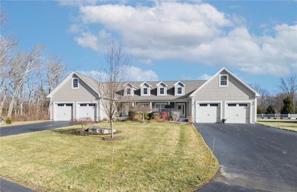 new england style home with a garage and a front yard