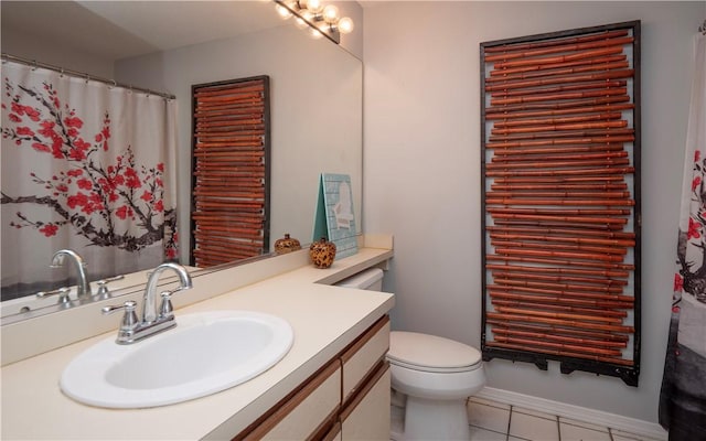 bathroom with toilet, vanity, and tile patterned flooring