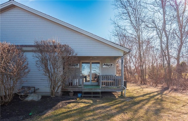 back of property with a lawn and a porch