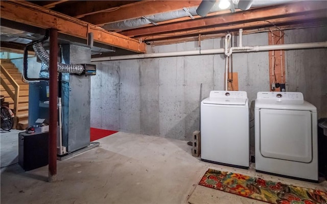 basement featuring heating unit and separate washer and dryer