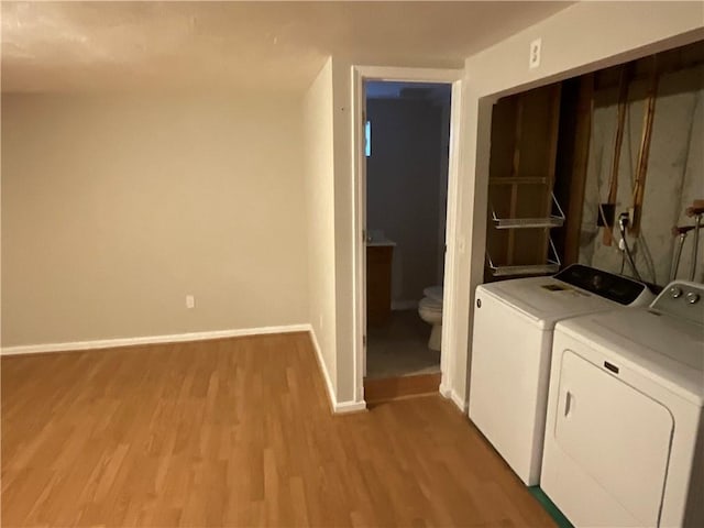 laundry room featuring washer and dryer and light hardwood / wood-style flooring