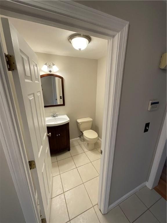 bathroom with toilet, tile patterned floors, and vanity