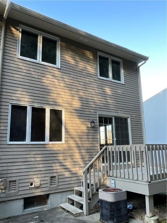 rear view of house with a wooden deck and central AC unit