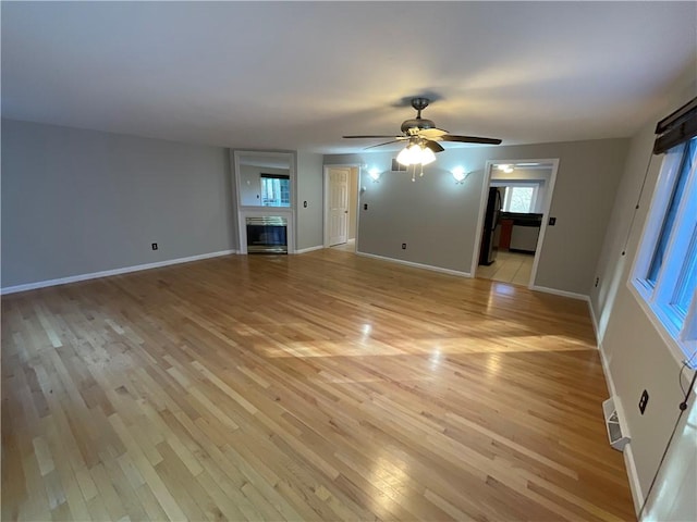 unfurnished living room featuring ceiling fan and light hardwood / wood-style flooring