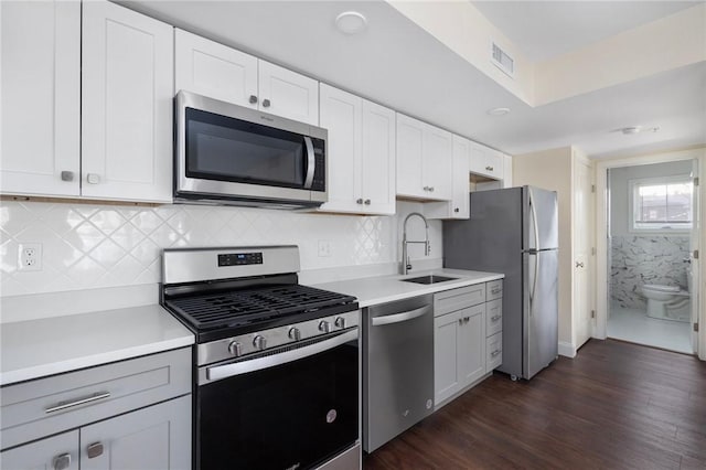 kitchen featuring dark hardwood / wood-style floors, stainless steel appliances, white cabinetry, and sink