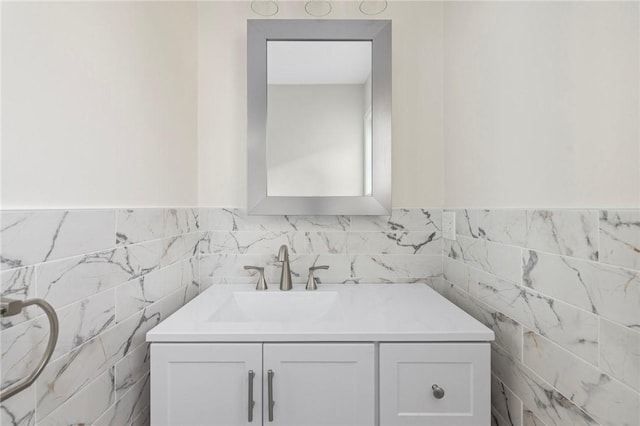 bathroom with vanity and tile walls