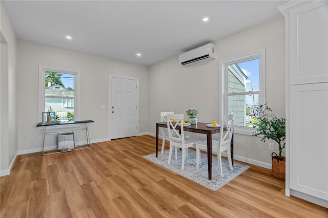 dining room with plenty of natural light, light wood-type flooring, and a wall mounted air conditioner