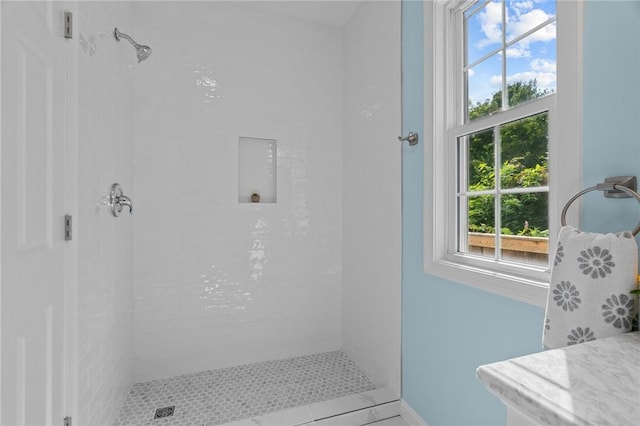 bathroom with tile patterned floors and tiled shower