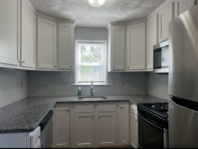 kitchen with backsplash, sink, white cabinetry, and appliances with stainless steel finishes