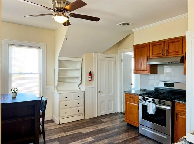 kitchen with stainless steel gas range, dark wood-type flooring, decorative backsplash, ceiling fan, and crown molding