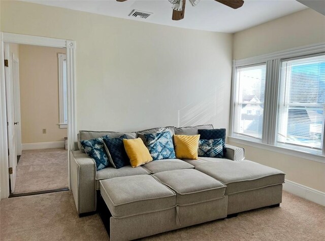 carpeted living room with ceiling fan