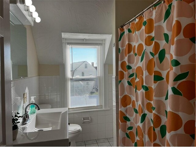 bathroom featuring toilet, vanity, tile patterned flooring, tile walls, and a shower with shower curtain