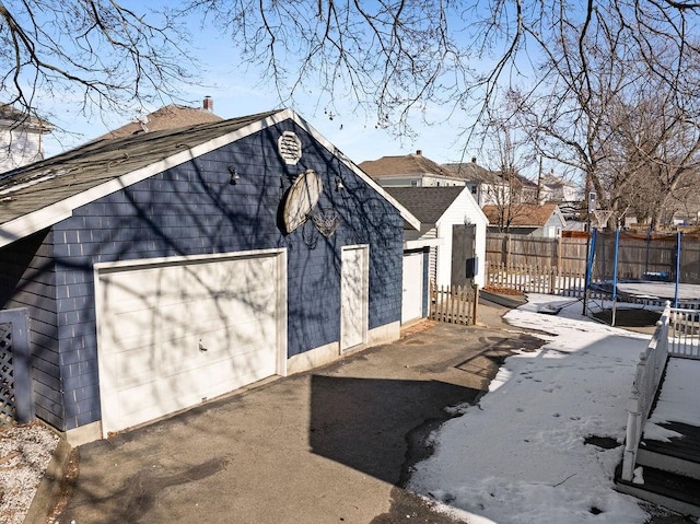 view of side of property with a garage and a trampoline