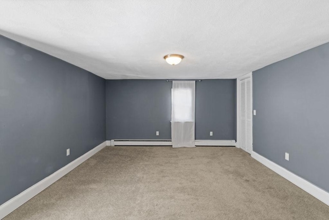 empty room with a baseboard heating unit and light colored carpet