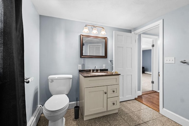 bathroom with baseboard heating, vanity, and toilet