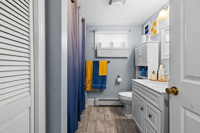 bathroom with a baseboard radiator, vanity, and toilet