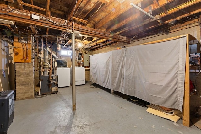 basement featuring washing machine and clothes dryer and electric panel