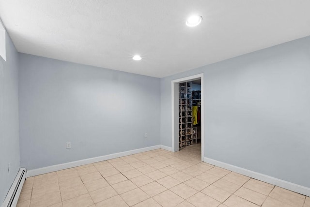 tiled spare room with a baseboard radiator