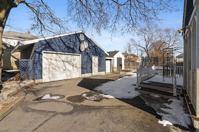 view of side of property with a garage, an outdoor structure, and a trampoline