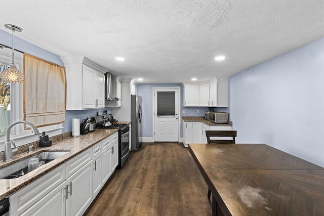 kitchen with sink, white cabinetry, hanging light fixtures, a textured ceiling, and stainless steel appliances