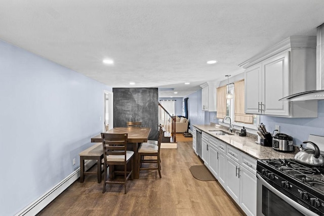 kitchen with white cabinetry, a baseboard radiator, stainless steel appliances, and light stone countertops