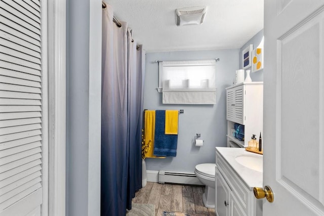 bathroom featuring baseboard heating, vanity, and toilet