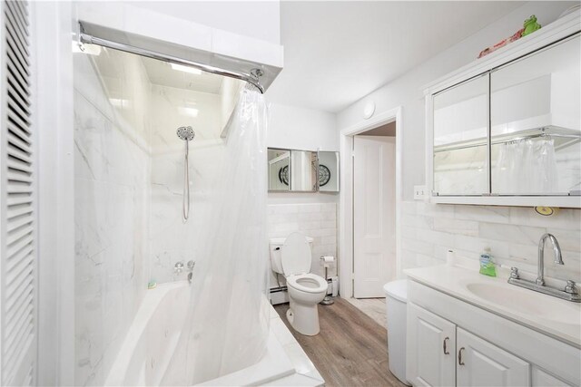 full bathroom featuring toilet, hardwood / wood-style flooring, baseboard heating, tile walls, and shower / bathtub combination with curtain