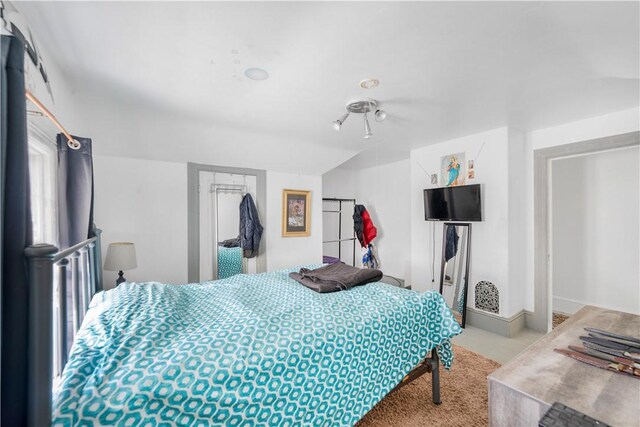 bedroom featuring lofted ceiling, light colored carpet, and a closet