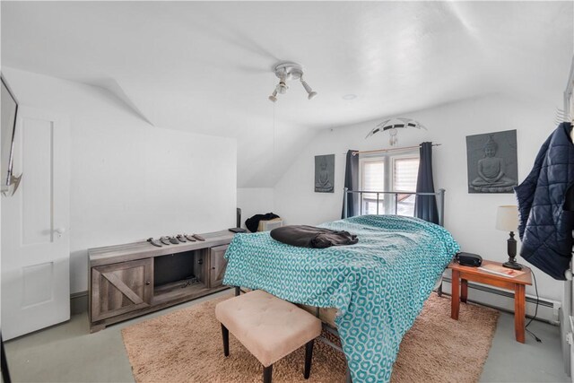 bedroom with a baseboard heating unit and vaulted ceiling