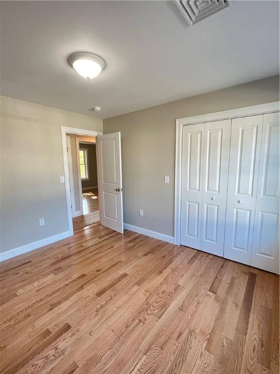 unfurnished bedroom featuring a closet and light hardwood / wood-style floors