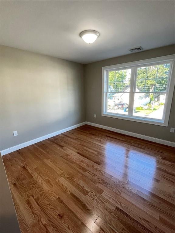 empty room with hardwood / wood-style flooring