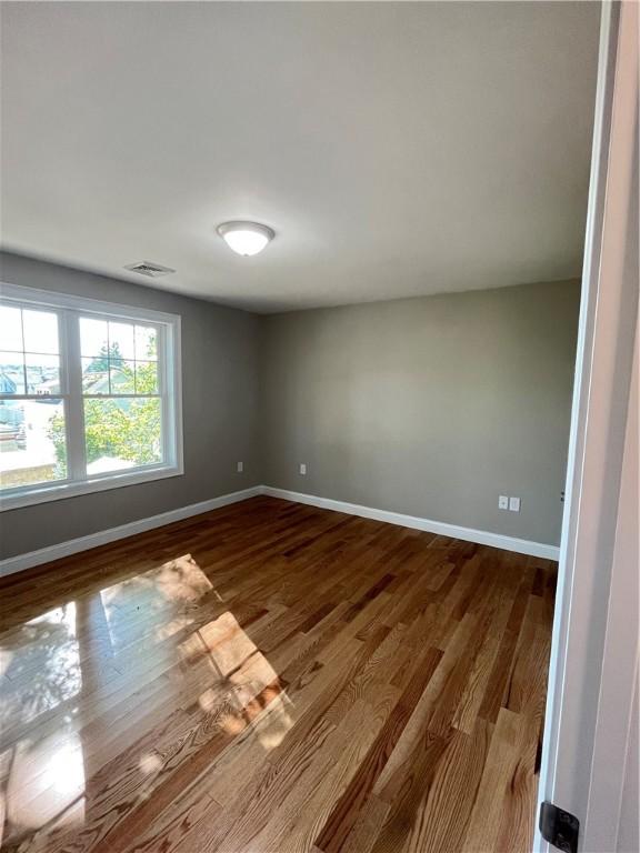 spare room with wood-type flooring