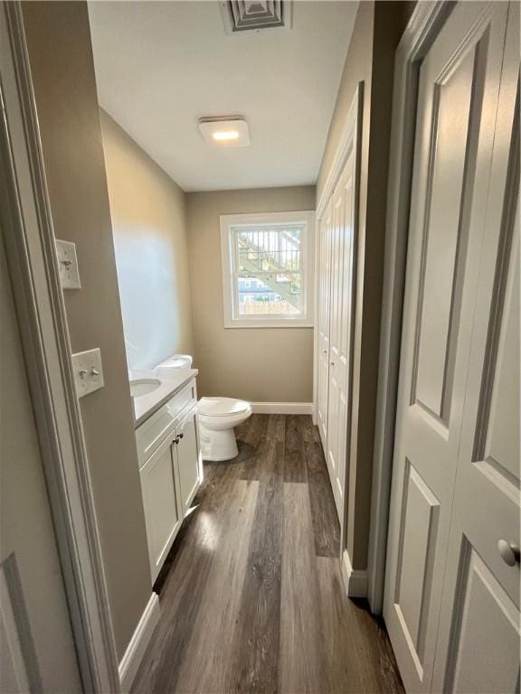 bathroom featuring hardwood / wood-style flooring, toilet, and vanity