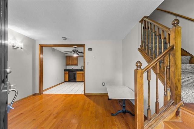 interior space featuring ceiling fan, wood-type flooring, and a textured ceiling