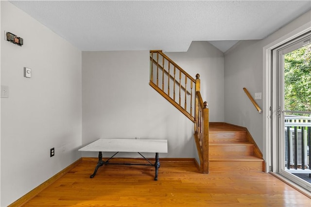 stairway featuring wood-type flooring and a textured ceiling