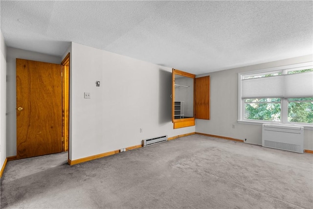 unfurnished room with a textured ceiling, baseboard heating, and carpet