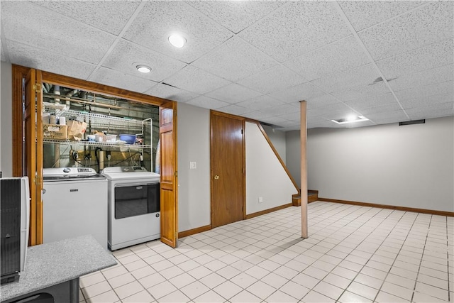 interior space featuring washer and clothes dryer and a drop ceiling